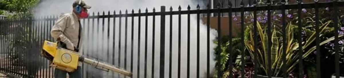 Mosquito control technician fogging a yard perimeter for mosquito reduction in Yonkers, NY